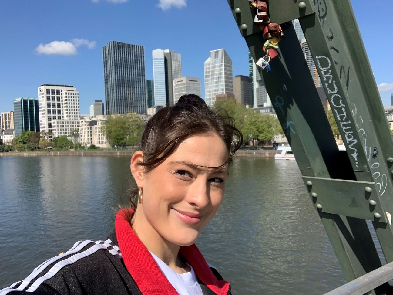 Selfie von Martha auf dem Eisernen Steg. Im Hintergrund sieht man die Frankfurts Wolkenkratzer-Kulisse.