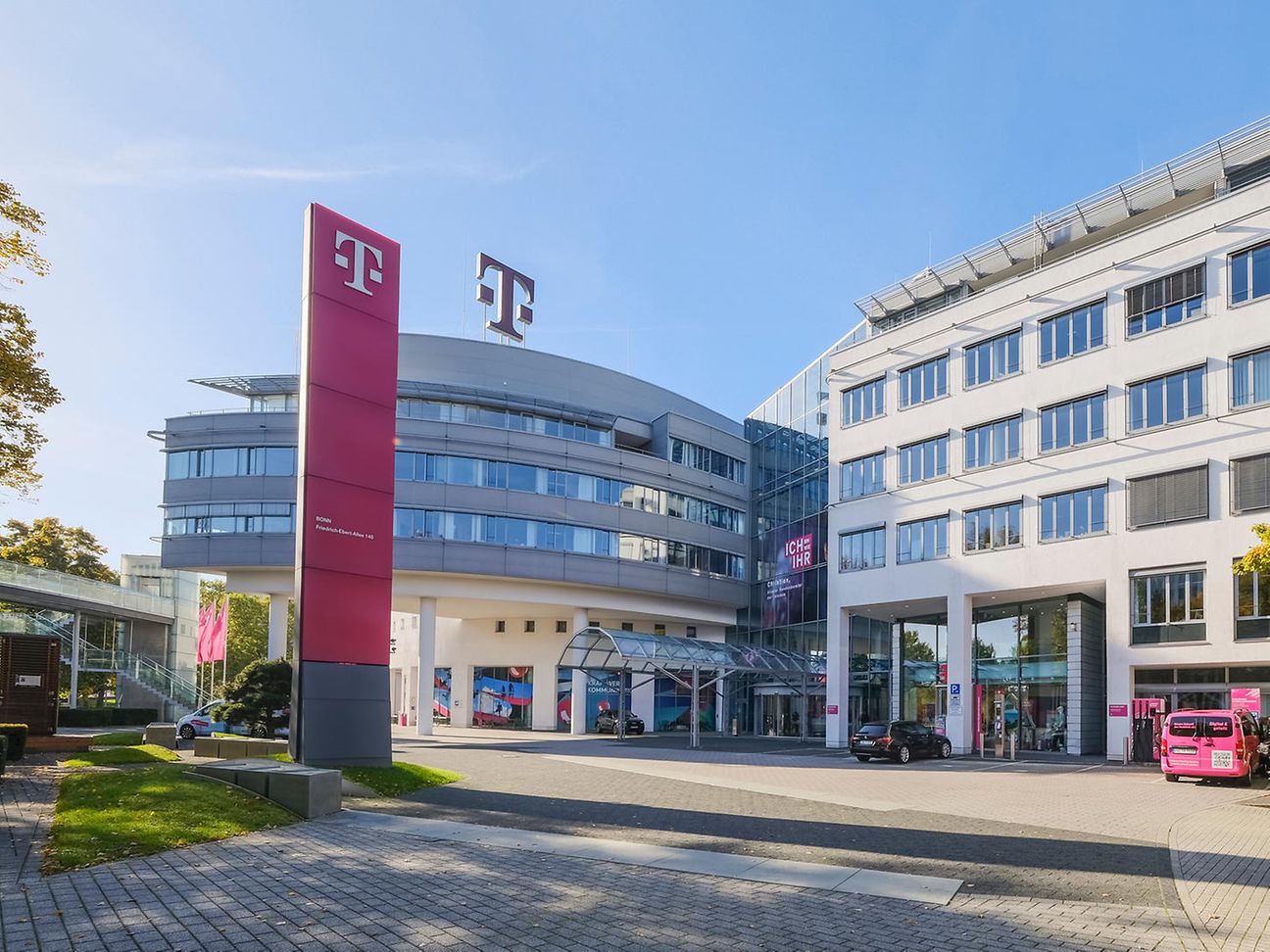 Exterior view of the Telekom headquarters in Bonn with magenta-colored flags in front