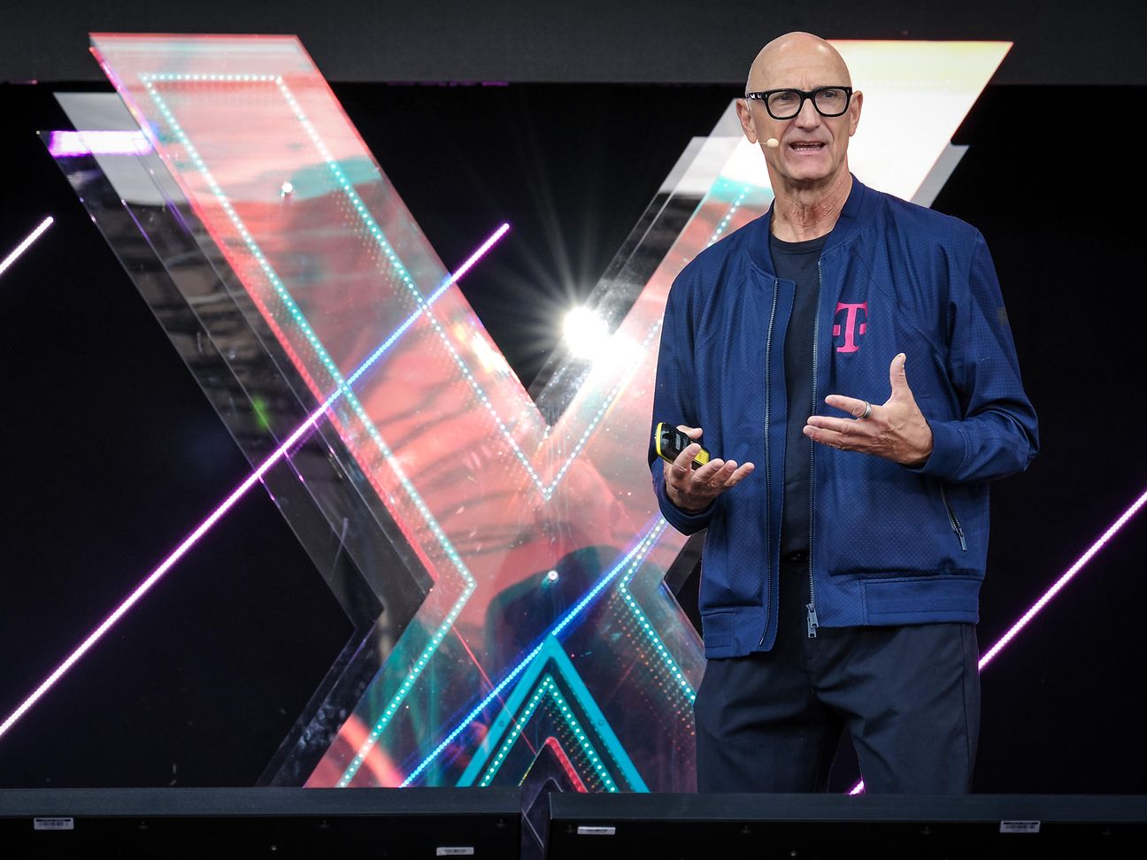 Tim Höttges vor einem „X“ auf der Bühne der Digital X. 