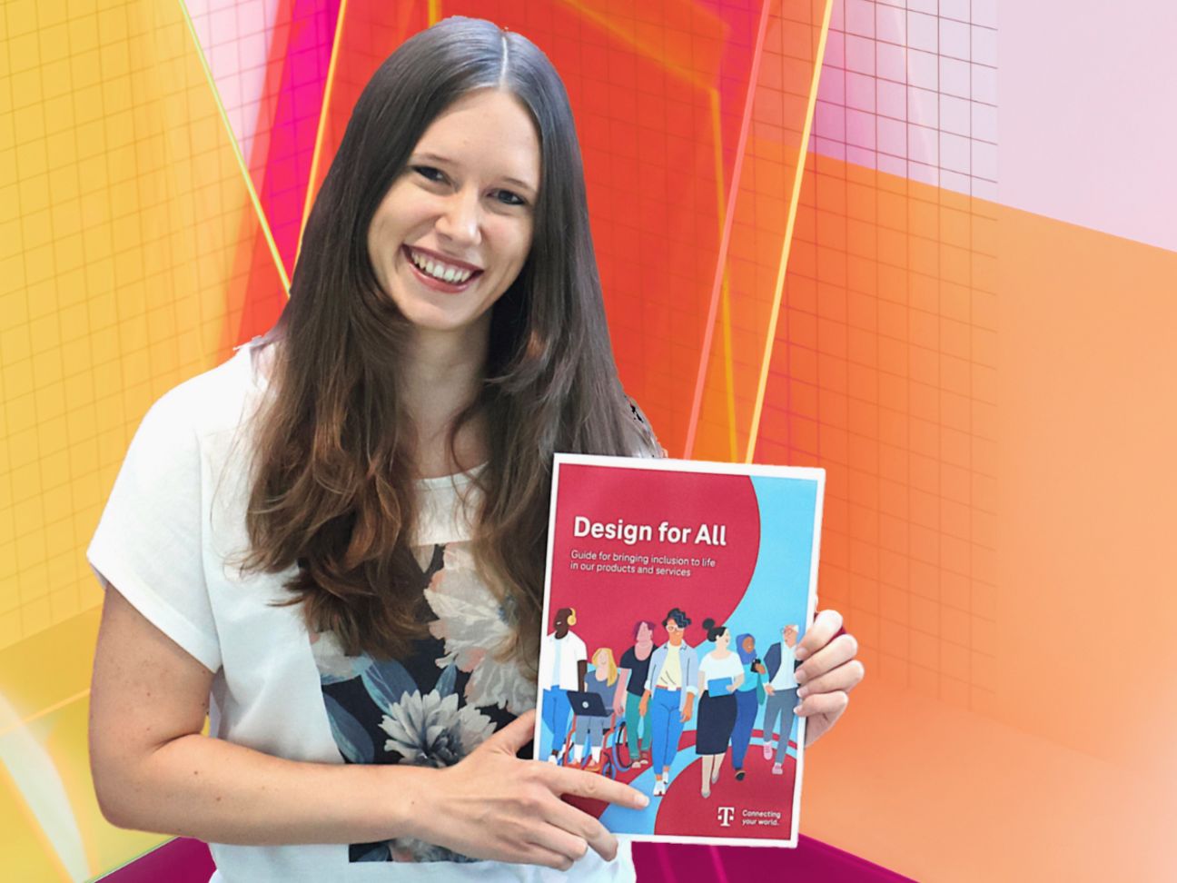 Annika Theiß hält den „Design für Alle Guide“ in der Hand. Sie steht vor einem bunten Design-Hintergrund.