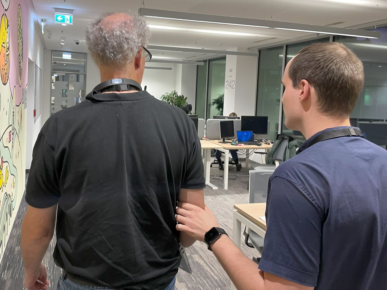 Zwei Männer gehen durch ein Büro.