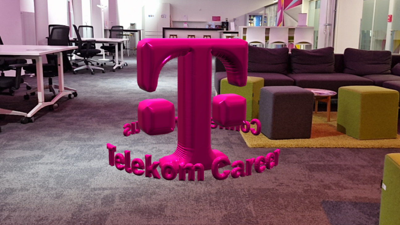 In a office, the T logo floats between furniture as an AR object with a balloon effect in the middle of the room