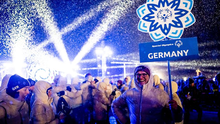 Mann mit Schild "Germany" bei Party zum Abschluss der Special Olympics Winterspiele.