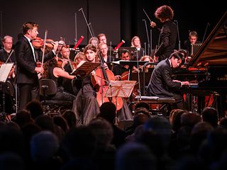 Julia Hagen (cello), Kit Armstrong (piano) and Renaud Capucon (violin) together with the Aurora Orchestra.