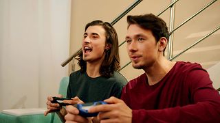 Zwei junge Männer schauen spielen ein Spiel über die Console