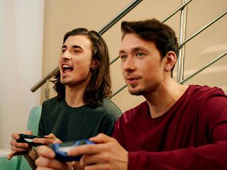 Zwei junge Männer schauen spielen ein Spiel über die Console