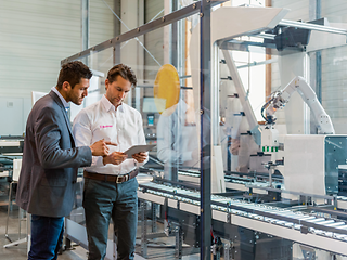 Two men with a tablet on the production line.