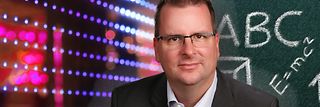 Alexander Nollen vor digitaler Tafel.