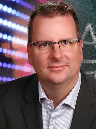 Alexander Nollen vor digitaler Tafel.