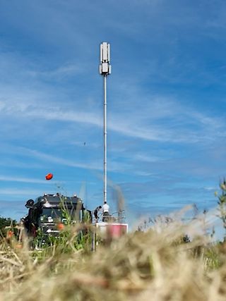 Mobilfunkmast auf Feld. Daneben ein LKW