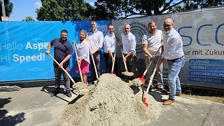 Der Bürgermeister von Asperg und die Vertreter von Telekom, SWLB und Zweckverband vor Sandhaufen.