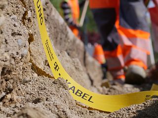 Sandgrube mit Hinweisband "T Kabel"