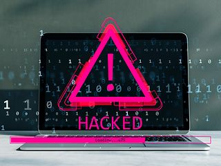 Schmuckbild: Laptop mit Warndreieck und dem Wort „Hacked“.