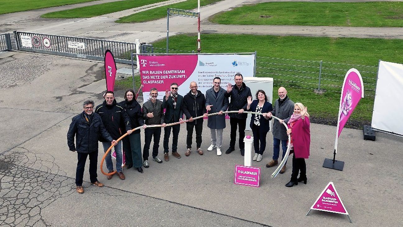 Gruppenaufnahme der Beteiligten aus der Vogelperspektive. Im Hintergrund die Start- und Landebahn des Flughafens Hahnweide. 