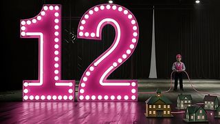 12 als Leuchtanzeiger und daneben ein Mann mit Schutzhelm