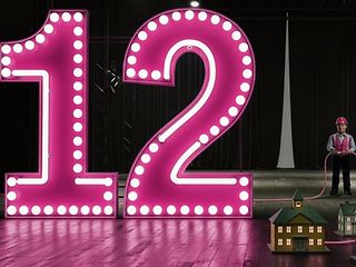 12 als Leuchtanzeiger und daneben ein Mann mit Schutzhelm