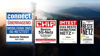 Mobilfunkmast in einer hügeligen Landschaft bei Sonnenaufgang. Im Vordergrund sind vier Testsiegel.