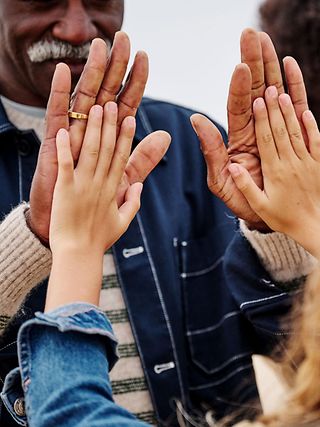 Two people clap hands, symbolizing unity, trust, and collaboration.