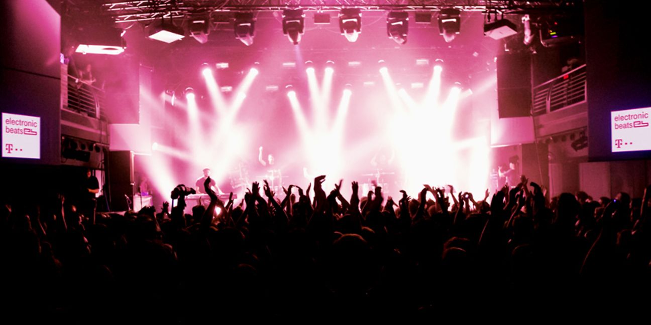 Tanzende Menge und DJ in der Electronic Beats Konzerthalle.