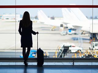 Silhouette of woman with suitcase at the airport
