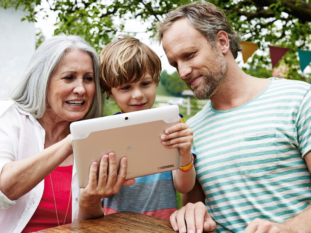 Großmutter, Vater und Sohn am Tablet-Computer.