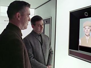 Two men in front of a flatscreen. A scene out of the movie "2001 – A Space Odyssey".