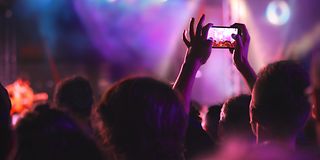 Zuschauer in Publikum fotografiert mit Smartphone