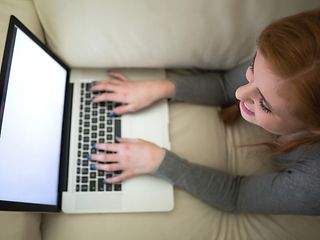 Young woman with laptop on sofa