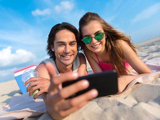 Zwei Teenager machen am Strand ein Selfie. 