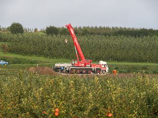 Ein Kranwagen wartet auf der Baustelle, um den Mast aufzustellen.