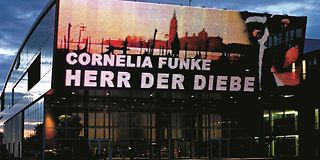 Fassade des Telekom Forum Bonns mit einer Werbung für das Theaterstück "Der Herr der Diebe" von Cornelia Funke.