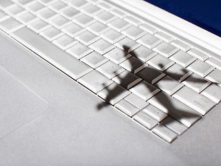 Der Schatten eines Flugzeugs ist schemenhaft auf einer Computertastatur zu sehen