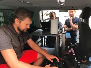 A view into the bus: Tomáš Kašparec and Lukáš Kratochvíl (front) prepare the 5G tests with a Huawei colleague.