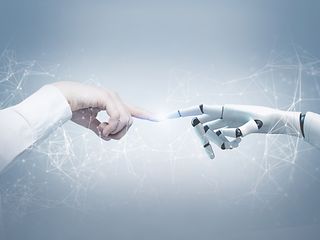 Menschliche Hand und Roboterhand berühren sich.