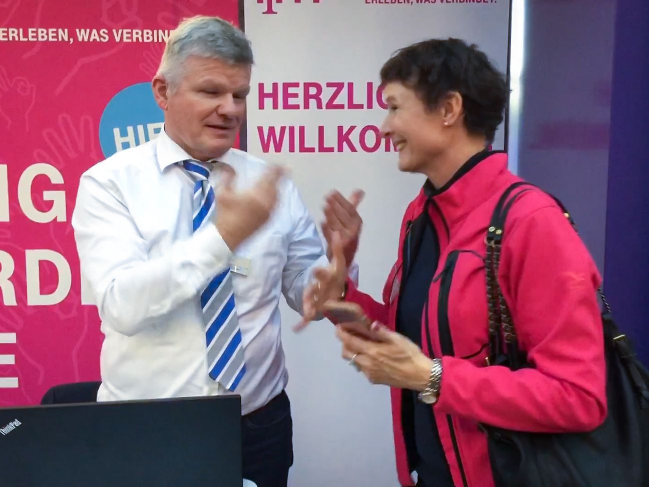 Christian Ebmeyer (left) and Katja Werz (right) communicating at the trade show for the deaf in Düsseldorf.