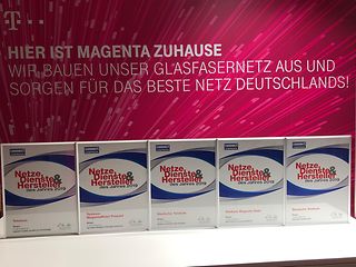 Fünf der sieben Telekom-Preise der connect Leserwahl 2019 stehen aufgereiht vor einer Magenta-Wand.