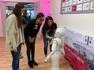 3 students talking to a robot
