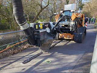 Beim Trenching wird nur ein schmaler Schlitz in den Asphalt gefräst. Das beschleunigt den Ausbau um ein Vielfaches.