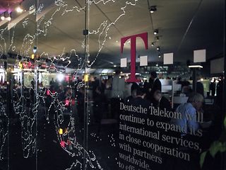 A world map, etched into a window pane, showing Deutsche Telekom's locations.