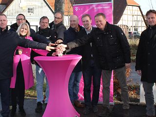 Sabine Wittlinger und acht Herren stehen vor einem Netzverteiler in Bempflingen. 