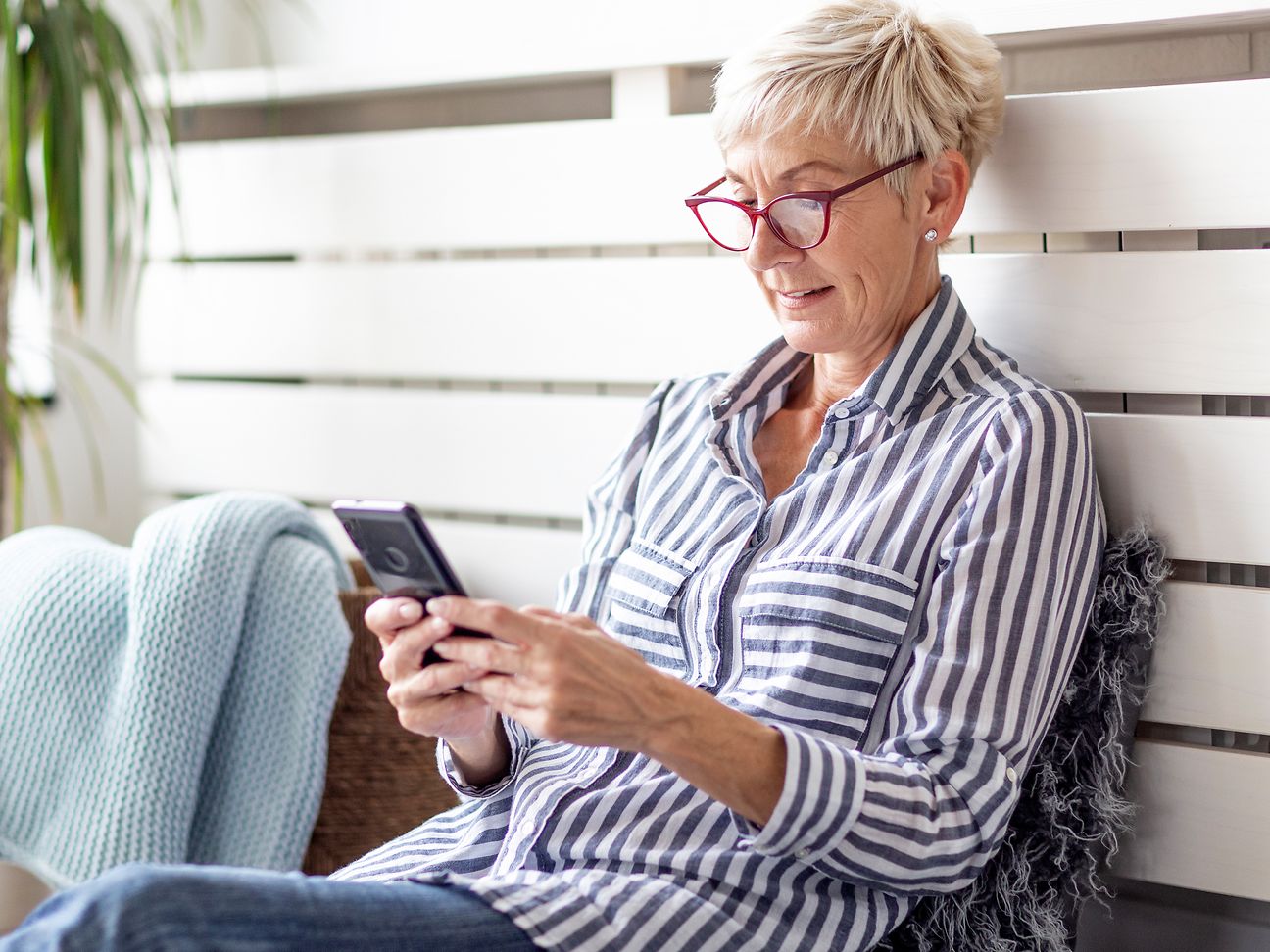 Eine ältere Dame führt ein Telefonat mit dem Handy.
