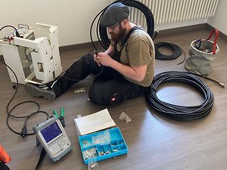 Telekom-Techniker Gustav Zahn baut als erste Hilfsmaßnahme einen Repeater für die bessere Netzabdeckung im Gebäude auf. 