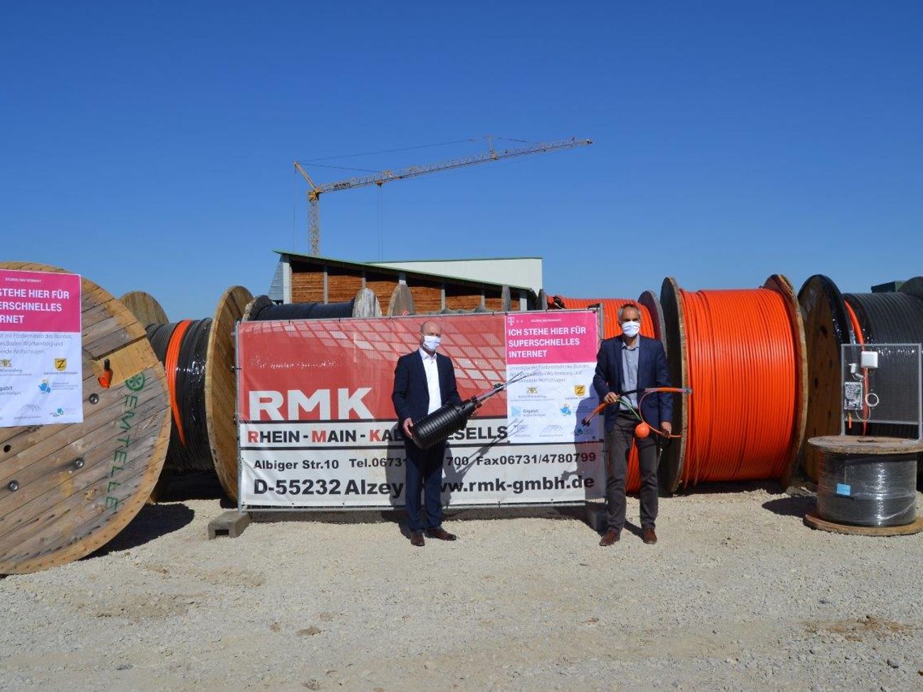 Telekom-Regionalmanager Josip Nadj (links) und Bürgermeister Matthias Ruckh stehen vor Glasfaserrollen.