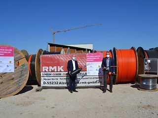 Telekom-Regionalmanager Josip Nadj (links) und Bürgermeister Matthias Ruckh stehen vor Glasfaserrollen.