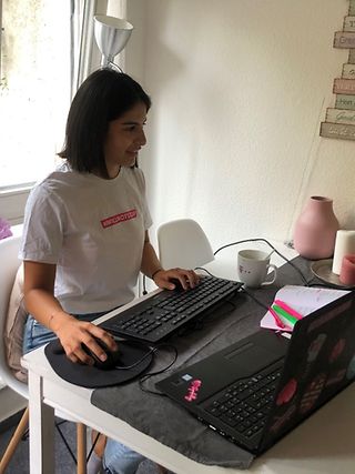A colleague sits in front of her workplace in the home office