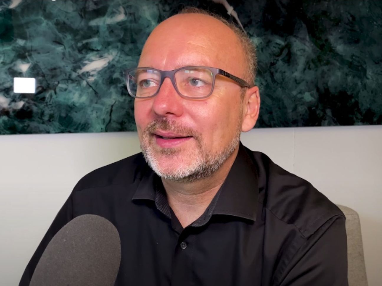 Mann wird mit Mikrofon interviewt