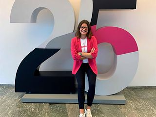 Woman stands in front of a big 25 on the occasion of Deutsche Telekom AG’s 25-year anniversary.