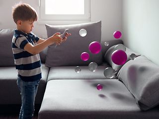 Junge spielt mit virtuellen Bällen.