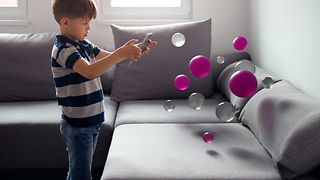 A boy – playing with virtual balls.