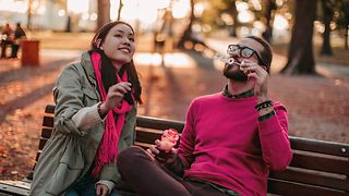 Eine Frau und ein Mann auf einer Parkbank.